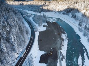 Transport trucks hauling trailers travel on the Coquihalla Highway after it was reopened to commercial traffic as heavy equipment is used to rebuild the southbound lanes that were washed away by flooding last month at Othello, northeast of Hope, B.C., on Monday, December 20, 2021.