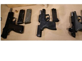 Three handguns seized by police from two alleged gunmen accused in a Thursday afternoon shooting in Toronto's west end on Thursday