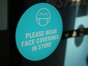 Eine Beschilderung mit Gesundheitsinformationen ist am Schaufenster eines Ladens im Stadtzentrum inmitten des Ausbruchs der Coronavirus-Krankheit (COVID-19) in Bolton, Großbritannien, am 19. Januar 2022 zu sehen.