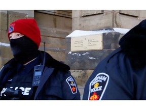 Durham Regional Police officers stand in front of the prime minister's office, as truckers and supporters take part in a convoy to protest COVID-19 vaccine mandates for cross-border truck drivers in Ottawa, Jan. 29, 2022.