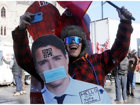A protester wears a cutout image of Prime Minister Justin Trudeau as truckers take part in a convoy to protest COVID-19 vaccine mandates for cross-border truck drivers in Ottawa, Jan. 29, 2022.
