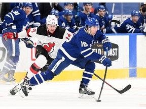 Toronto Maple Leafs forward Mitchell Marner passes the puck away from New Jersey Devils forward Nathan Bastian at Scotiabank Arena last night. USA TODAY Sports
