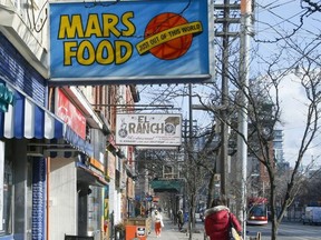 A woman walks by Mars Food on College St. on jan. 10, 2020, one of the many businesses which has closed during the pandemic.