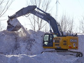 Dump trucks filled with snow removed from city streets deposit it at the Unwin Ave site on Friday, Jan. 21, 2022.