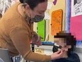 Teacher taping mask to student’s face.