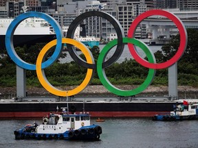 Boats prepare to tow giant Olympic rings as they are removed from the waterfront area at Odaiba Marine Park, after the Tokyo 2020 Olympic Games came to an end on August 8, in Tokyo, Japan, August 11, 2021.