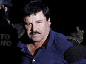 Recaptured drug lord Joaquin "El Chapo" Guzman is escorted by soldiers at the hangar belonging to the office of the Attorney General in Mexico City, Mexico January 8, 2016.