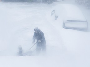 Homeowners work to clear snow on Monday, January 17, 2022, in Ajax.