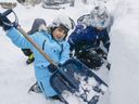 Children help clear a driveway on Monday January 17, 2022 in Ajax.  