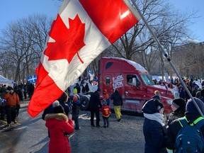 Protestors wave Canadian and Quebec flags at a gathering outside the National Assembly to protest against COVID-19 health restrictions in Quebec City on Feb. 5, 2022.