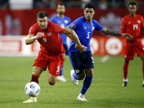 Lucas Cavallini (No. 9) of Canada chases the ball ahead of Ronald Rodriguez (No. 5) of El Salvador during a 2022 World Cup Qualifying match at BMO Field on September 8, 2021 in Toronto.