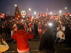 Protesters and supporters take a vote on whether to stay or leave ahead of an impending 7 p.m. injunction deadline at the foot of the Ambassador Bridge, sealing off the flow of commercial traffic over the bridge into Canada from Detroit, on Feb. 11, 2022 in Windsor, Ont.