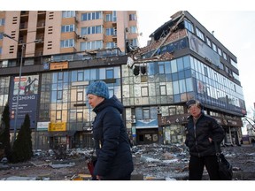 Frauen gehen an dem Wohnblock in der Lobanovsky Avenue 6A vorbei, der am 26. Februar 2022 in Kiew von einer Rakete getroffen wurde.