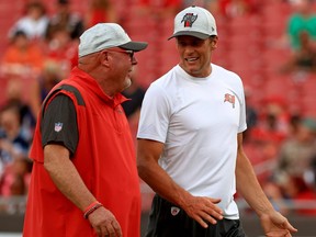 Head coach Bruce Arians and Tom Brady #12 of the Tampa Bay Buccaneers talk during a preseason game against the Tennessee Titans at Raymond James Stadium on August 21, 2021 in Tampa, Florida.