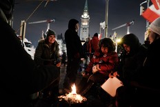 People keep warm by a fire as part of a convoy of truck protesters against COVID-19 mandates on February 9, 2022 in Ottawa. Spencer Platt/Getty Images