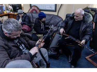 Civilian volunteers check their guns at a  Territorial Defence unit registration office on Feb. 26, 2022 in Kyiv.