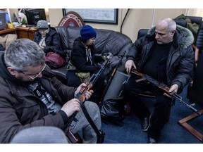 Zivile Freiwillige überprüfen am 26. Februar 2022 in Kiew ihre Waffen in einem Registrierungsbüro einer Territorial Defense Unit.