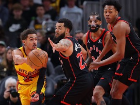 Trae Young of the Atlanta Hawks passes the ball against Fred VanVleet and Scottie Barnes of the Toronto Raptors on Saturday night.
