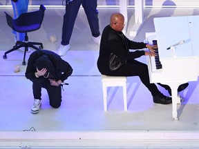 Rapper Eminem kneels on stage as he performs with US rapper Dr. Dre during the halftime show of Super Bowl LVI between the Los Angeles Rams and the Cincinnati Bengals at SoFi Stadium in Inglewood, California, on February 13, 2022.