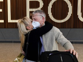 A passenger is greeted as he arrives at Melbourne's international airport on February 21, 2022 as Australia opens its international borders to all vaccinated tourists, nearly two years after the island nation first imposed some of the world's strictest COVID-19 travel restrictions.