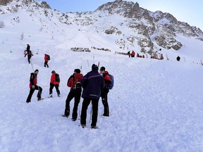 Rescue workers stand at the Rettenbach glacier near Soelden, on Feb. 4, 2022 after five winter sports enthusiasts were rescued after being hit by an avalanche.