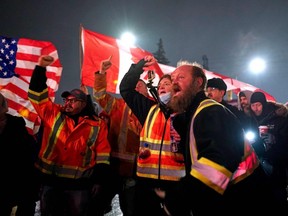 Anti-vaccine mandate protesters yell at a television crew as they record a live interview at a roadway near the Ambassador Bridge U.S.-Canada border crossing, in Windsor, Ont., Feb. 11, 2022.