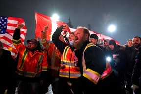 Demonstranten gegen das Impfmandat schreien ein Fernsehteam an, während sie am 11. Februar 2022 ein Live-Interview auf einer Straße in der Nähe des Grenzübergangs Ambassador Bridge zwischen den USA und Kanada in Windsor, Ontario, aufzeichnen.