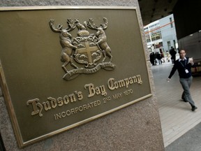A pedestrian walks past a Hudson's Bay company sign at the retailer's flagship Toronto store.
