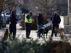 Police officers wait with their canines outside Dunbar High School as members of the Metropolitan Police Department of the District of Columbia conduct an investigation of a security threat at the school on February 8, 2022 in Washington, DC.