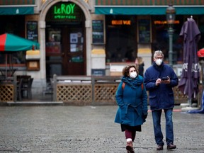 People wearing protective face masks walk at the Grand Place in Brussels, amid the rise of COVID-19 cases due to the Omicron variant in Belgium, Jan. 21, 2022.