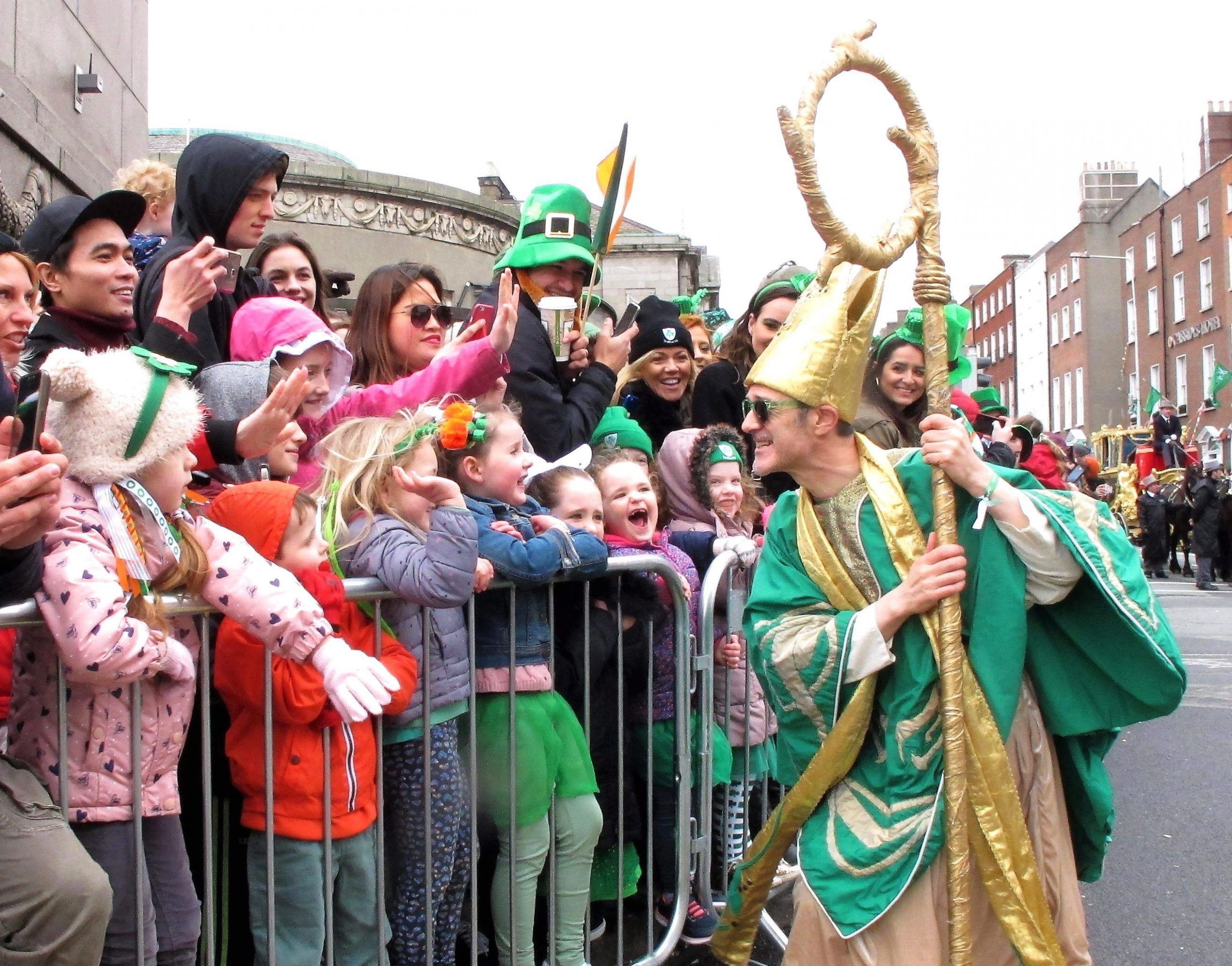 Saint Patrick as portrayed by Irish actor Johnny Murphy clowns around with children watching the St. Patrick's Day parade in Dublin, Ireland, Friday, March 17, 2017.