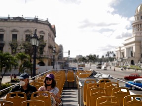 Two tourists sit on an empty bus in Havana, Cuba, February 16, 2022.