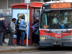 Menschen mit Masken werden gesehen, wie sie am 4. Februar 2022 in der Innenstadt von Calgary in einen Stadtbus einsteigen.