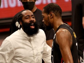 James Harden, left, of the Brooklyn Nets congratulates teammate Kevin Durant after the third quarter against the Milwaukee Bucks during game two of the Eastern Conference second round series at Barclays Center on June 7, 2021 in the Brooklyn borough of New York City.