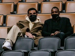 Toronto rapper Drake sits in the stands with Raptors president Masai Ujiri during a game against the Heat at Scotiabank Arena on Tuesday, Feb. 1, 2022.