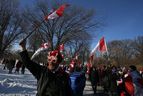 Menschen schwenken am Samstag, den 5. Februar 2022, während des Trucker-Protestes in der Innenstadt von Toronto kanadische Flaggen.