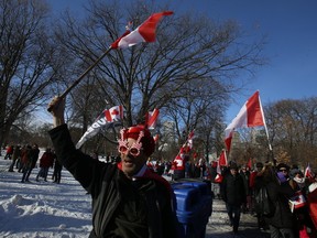 People wave Canadian flags during the trucker protest in downtown Toronto on Saturday, Feb. 5, 2022.