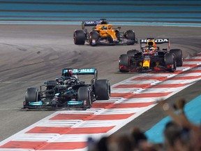 Mercedes' British driver Lewis Hamilton is followed by Red Bull's Dutch driver Max Verstappen at the Yas Marina Circuit during the Abu Dhabi Formula One Grand Prix on December 12, 2021.