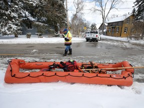 A village in Brampton known as Churchville had 100 homes flooded on Thursday as rains surged the Credit River sending huge chunks of ice down the river. (Pictured) A City of Brampton engineer walks by a water rescue float used to help workers get to flooded areas on Friday, Feb. 18, 2022.