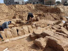 Men work in a newly discovered Roman cemetery in Gaza, in this handout photo obtained by Reuters, February 17, 2022.