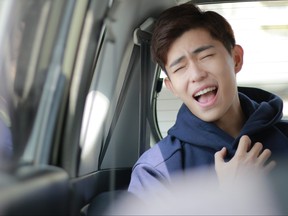 A young man is enjoying singing in the car.