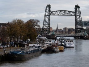 A picture shows barges docked on the Koningshaven waterway as they Koningshavenbrug "De Hef" lift bridge (right, rear) and the Koninginnebrug drawbridge (right, front) are seen in the background in Rotterdam, western Netherlands, on Nov. 23, 2021.