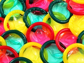 A close up image of a multitude of colored condoms
