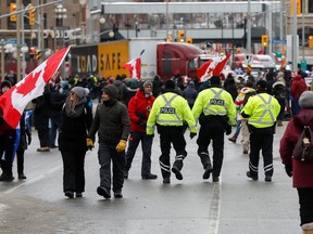 Police officers walk in the crowd, as truckers and supporters continue to protest coronavirus disease (COVID-19) vaccine mandates, in Ottawa February 6, 2022.