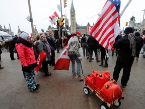 A man hauls canisters of fuel in front of Parliament Hill as truckers and their supporters continue to protest in Ottawa  February 6, 2022.