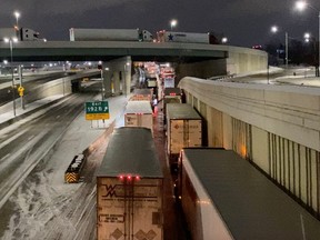 Truckers stand in line as they block the Ambassador Bridge (not pictured) on the I-75 and I-96 highways in Detroit, Michigan, U.S., February 7, 2022,  in this still image taken from a handout video obtained by Reuters on February 8, 2022.