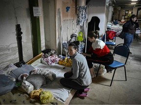 Women look after their babies at the pediatrics centre after the unit was moved to the basement of the hospital which is being used as a bomb shelter, in Kyiv on February 28, 2022.