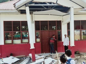Residents inspect a building damaged by a magnitude 6.2 earthquake at Kajai village in West Pasaman on February 25, 2022.