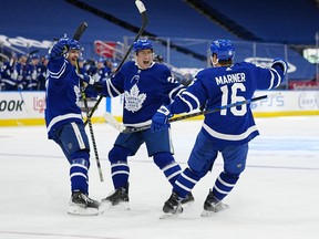 Maple Leafs' Timothy Liljegren and defenceman Travis Dermott celebrate a goal by forward Mitchell Marner during the third period against the Carolina Hurricanes at Scotiabank Arena on Monday, Feb. 7, 2022.