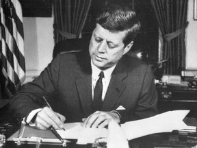 This file photo taken Oct. 24, 1962, shows U.S. President John F. Kennedy signing the order of naval blockade of Cuba at the White House in Washington, D.C., during the Cuban missiles crisis.